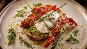 smashed-avocado-poached-egg-toasted-sourdough-bread-crispy-bacon-chorizo